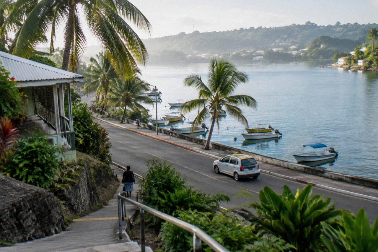 Port Vila seafront road with palm trees and moored boats on a bright morning