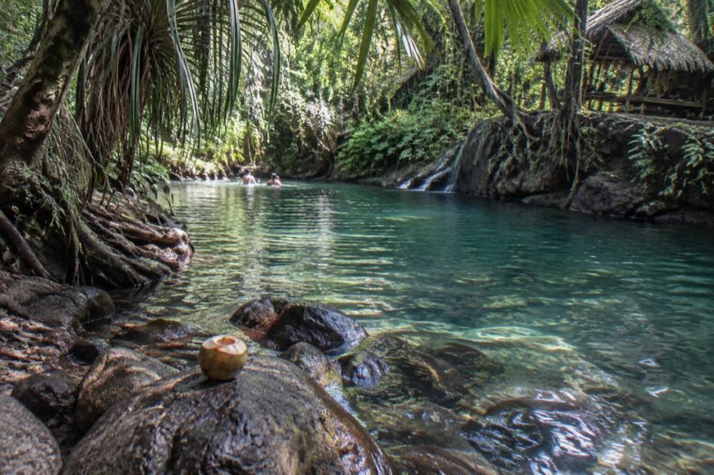 A blue freshwater lagoon surrounded by jungle vegetation on Efate