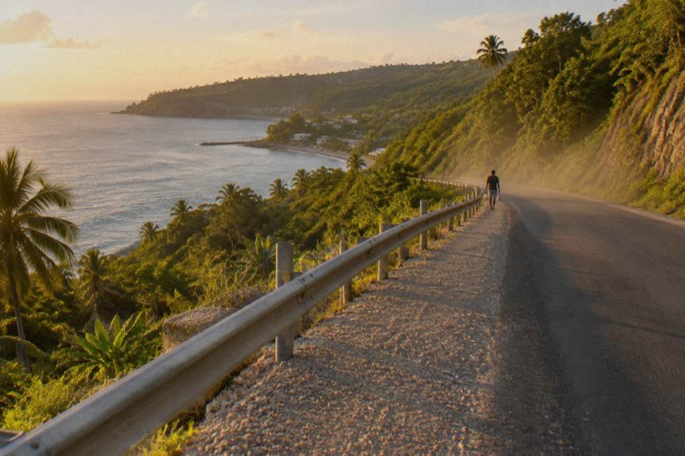 A coastal road winding along green cliffs on the Efate ring road