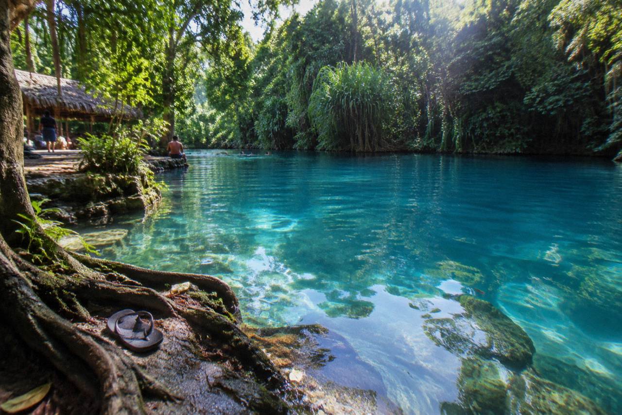 Turquoise lagoon water ringed by dense green jungle on Efate island