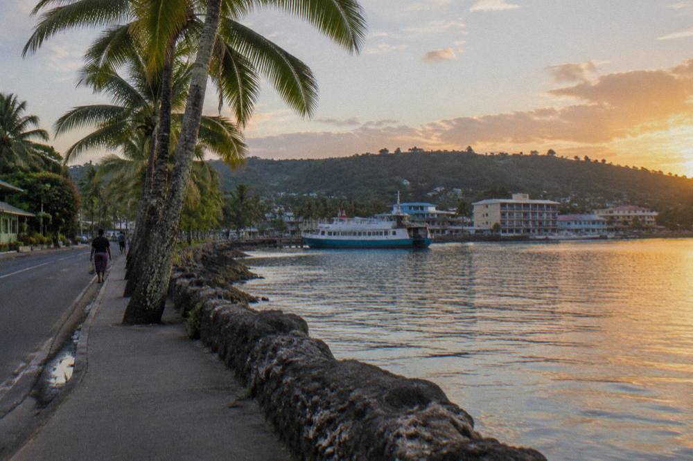 Waterfront road in Port Vila with palm trees and calm harbour water