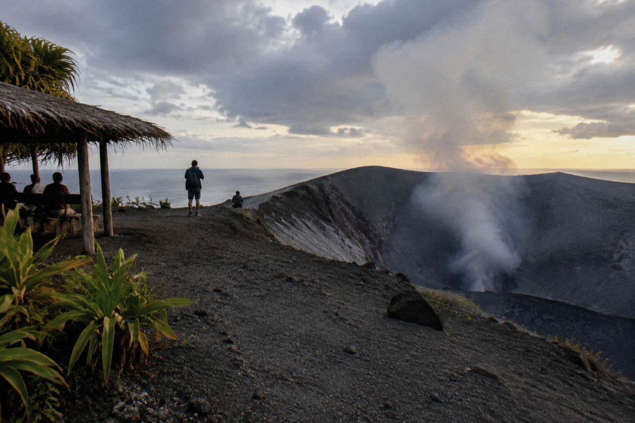 Mount Yasur volcano crater on Tanna Island at dusk with a low ash plume above the rim
