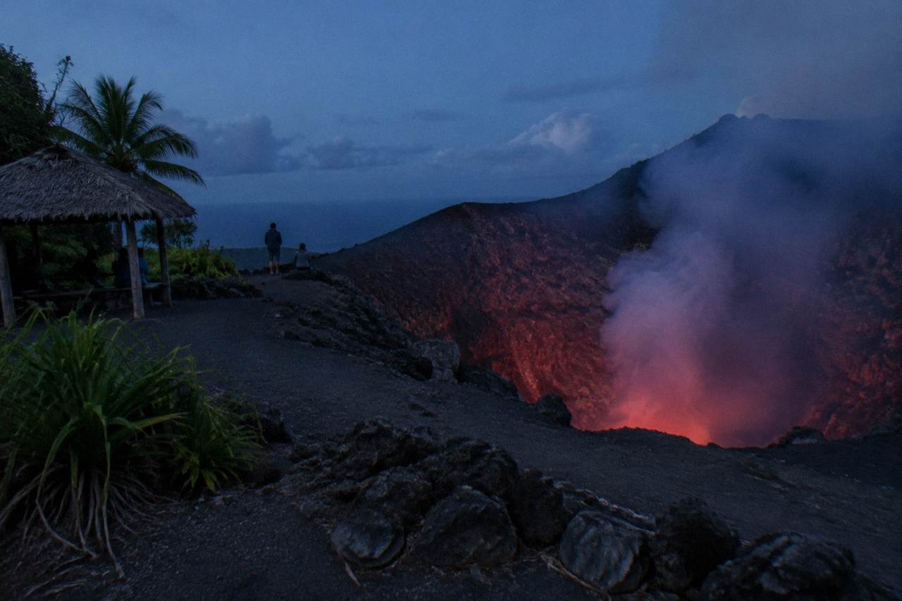 Mount Yasur volcano crater on Tanna Island at dusk with smoke rising from the vent