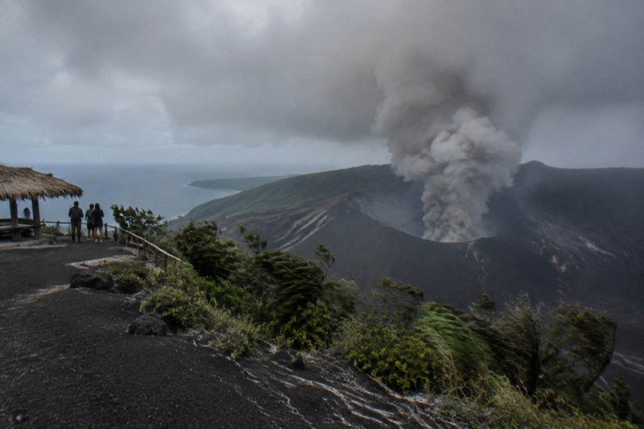 Ash plume rising from the crater of Mount Yasur volcano on Tanna Island under a grey sky