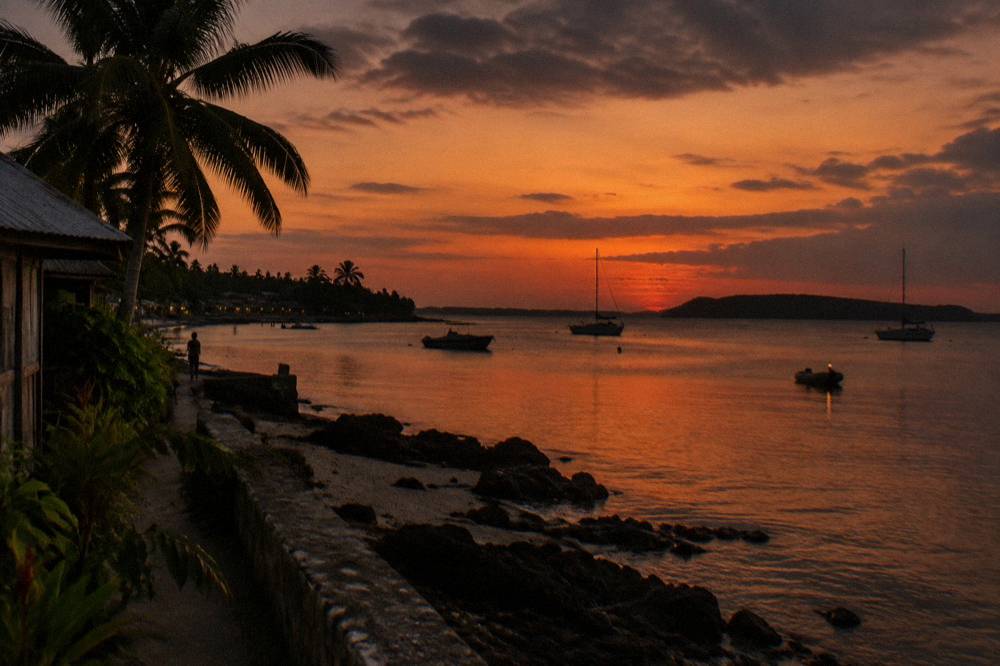 Sunset light over calm sea with a distant island silhouette on the horizon