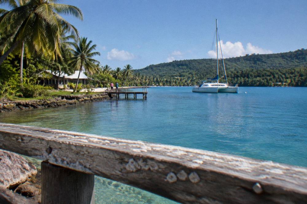Wooden bench overlooking a blue lagoon surrounded by tropical trees in Vanuatu
