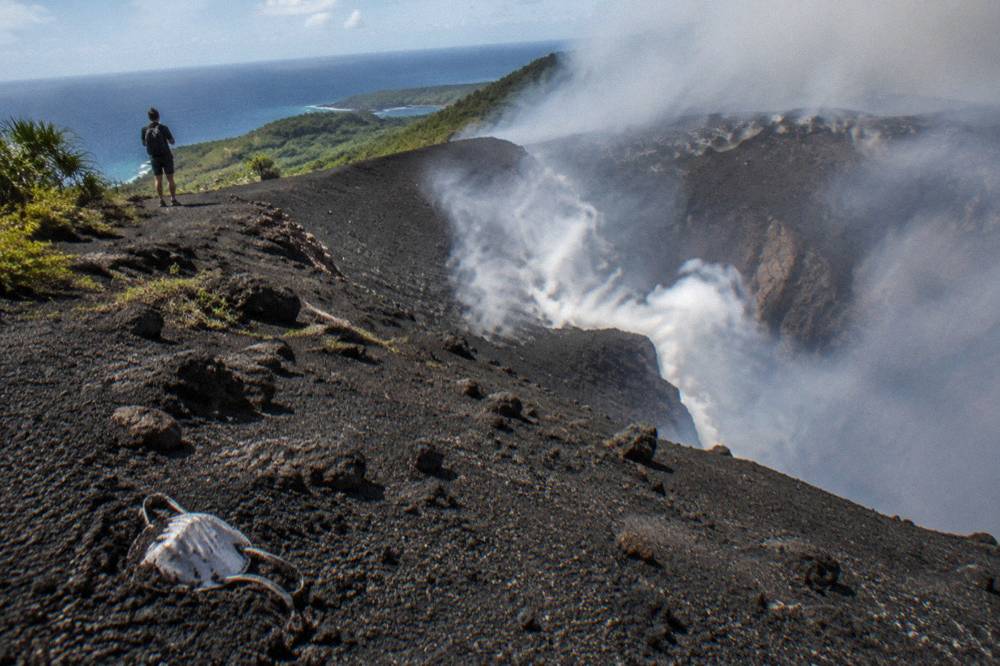 Volcanic landscape with a smoky crater rim under an open sky