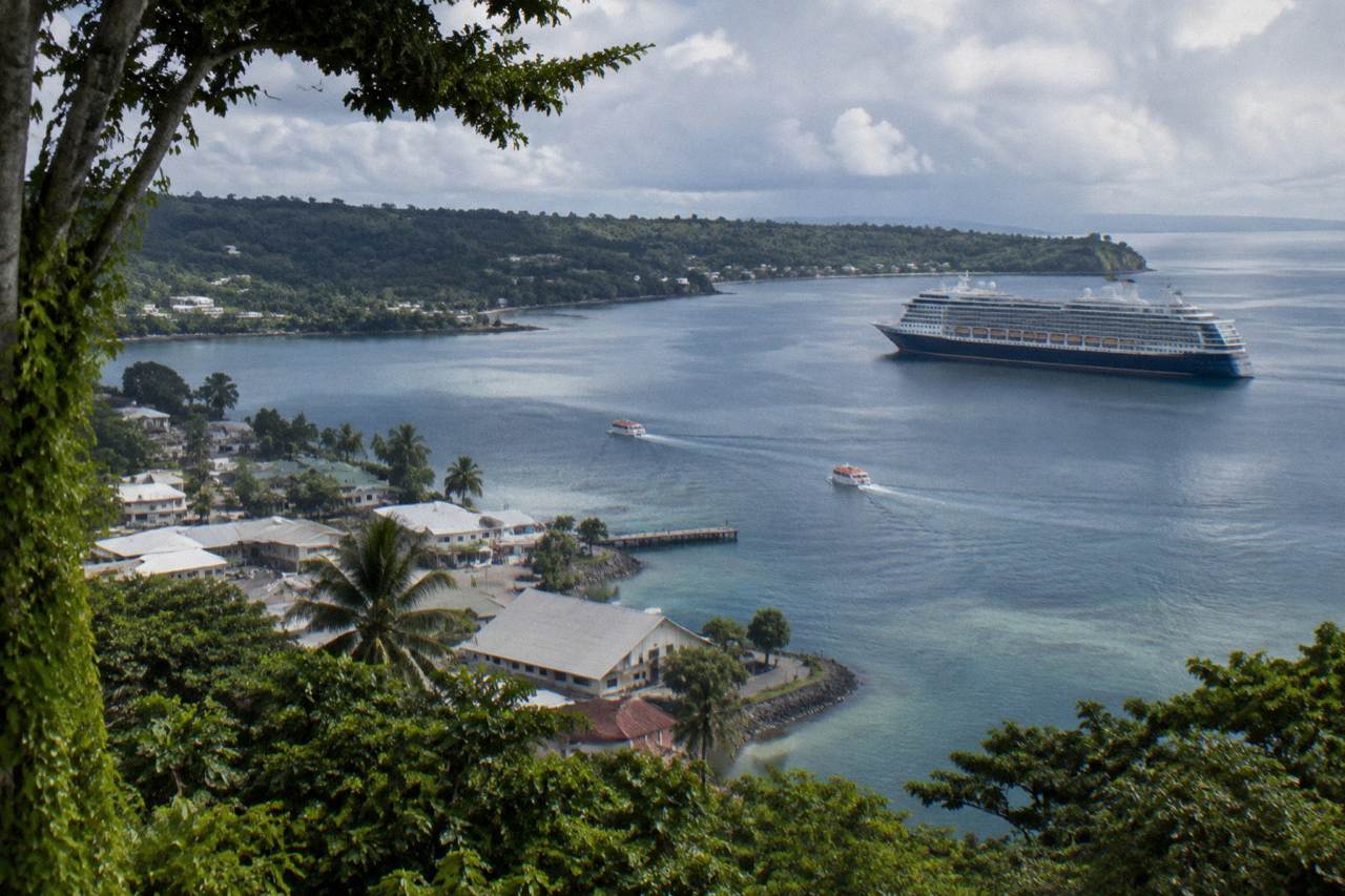 Cruise ship anchored off Port Vila with tender boats crossing the harbour toward the seafront