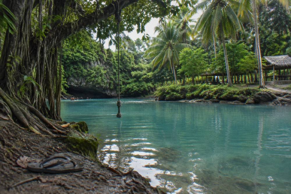 Turquoise blue lagoon surrounded by dense green jungle on Efate