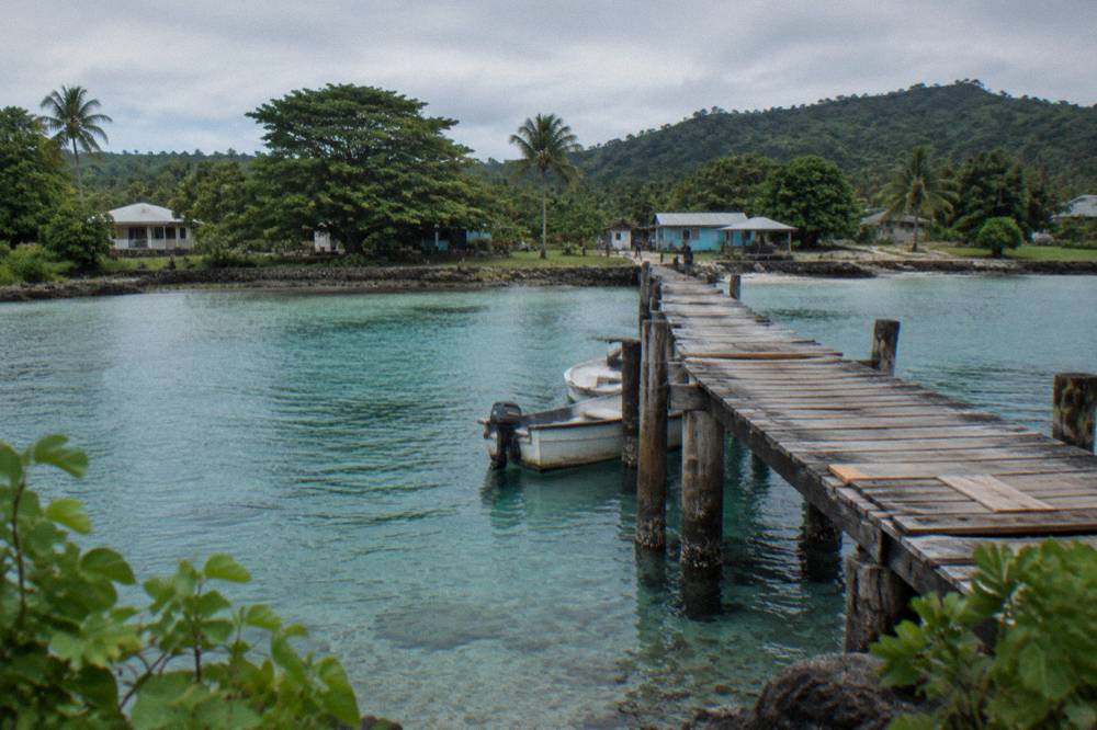 Wooden jetty extending over turquoise lagoon water