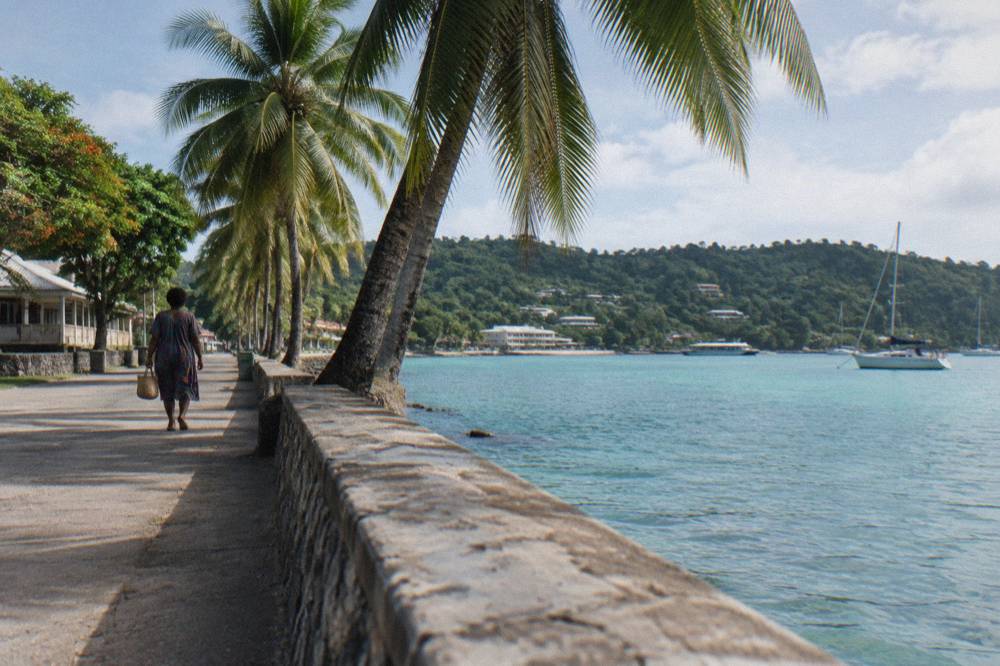 Seafront promenade in Port Vila with palm trees and calm turquoise harbor water